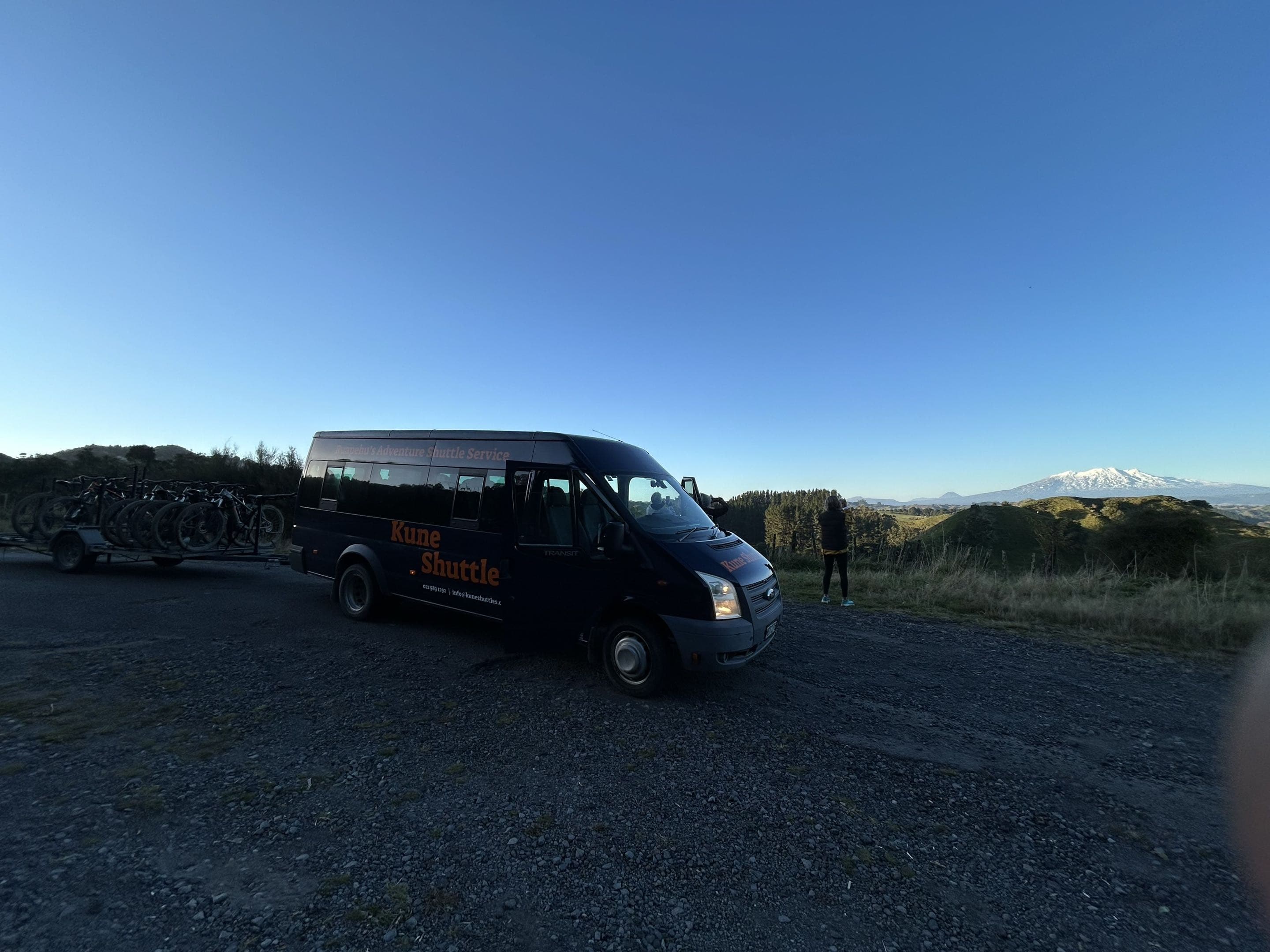 Kune shuttle van below Mt Ruapehu at dusk, bike trailer loaded